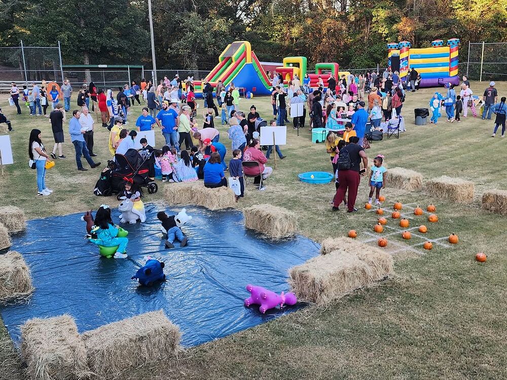 Families on the field at Bethel&rsquo;s Fall Festival, with inflatables, hay bales and pumpkins